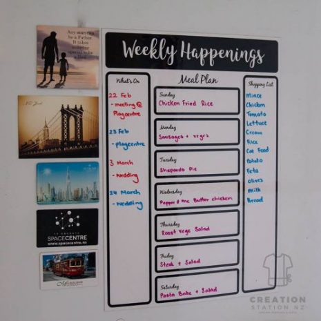 Images shows a fridge with a magnetic whiteboard planner attached. It has black boxes for Whats On, Meal Plan and Shopping.